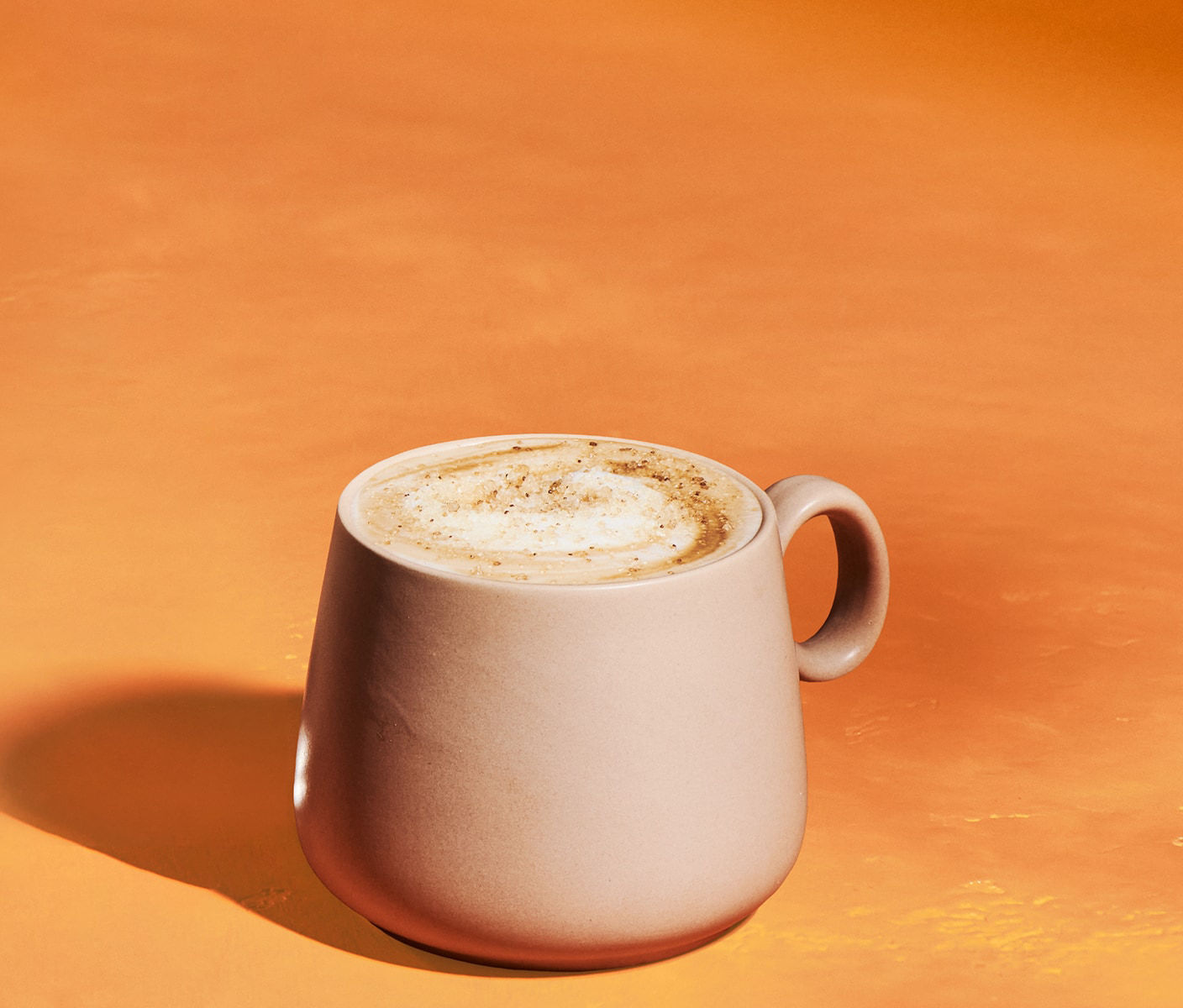 Latte dans une tasse, surmonté de mousse et d’une garniture.