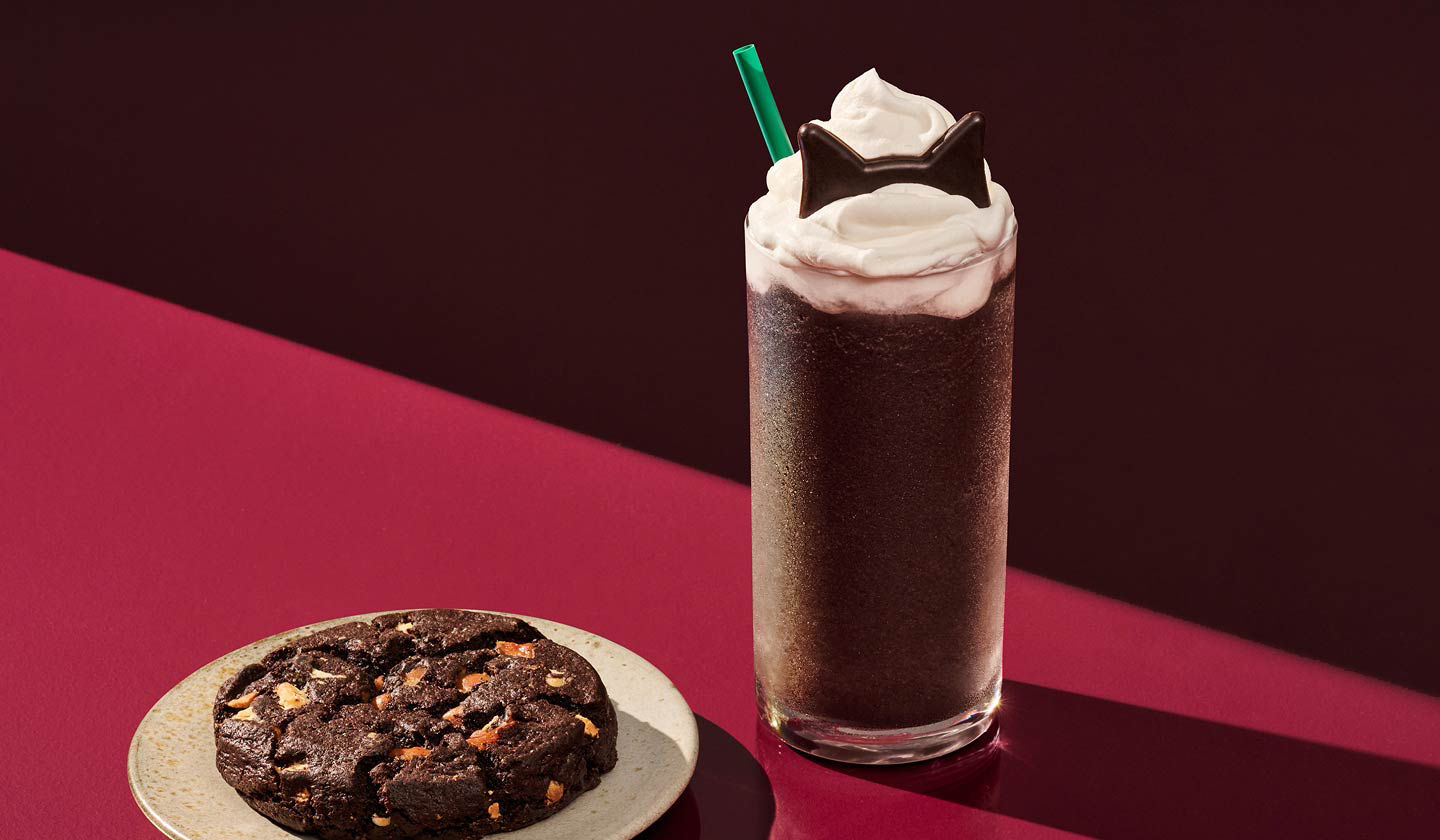The Black Cat Frappuccino drink sitting next to the Black Night Cookie 